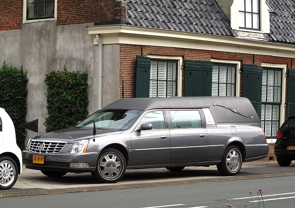 Серый легковой катафалк Cadillac DTS, вид сбоку